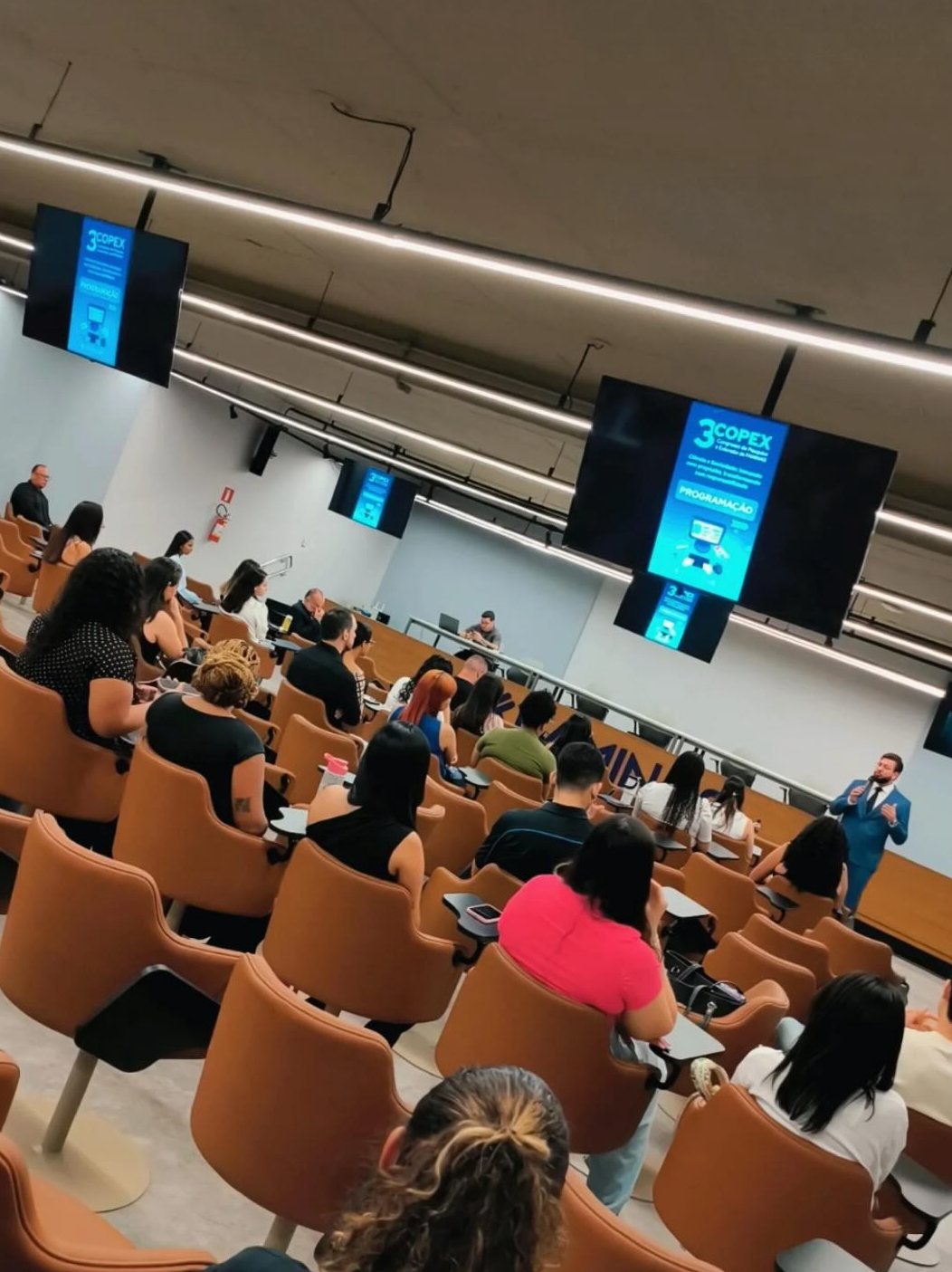 Aula em auditório lotado de estudantes e advogados